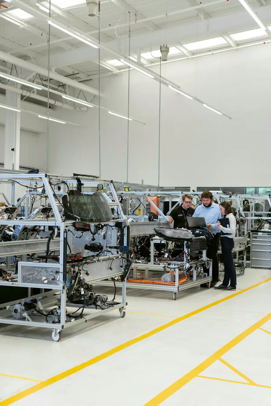 Engineers reviewing a machine build on a laptop in a workshop