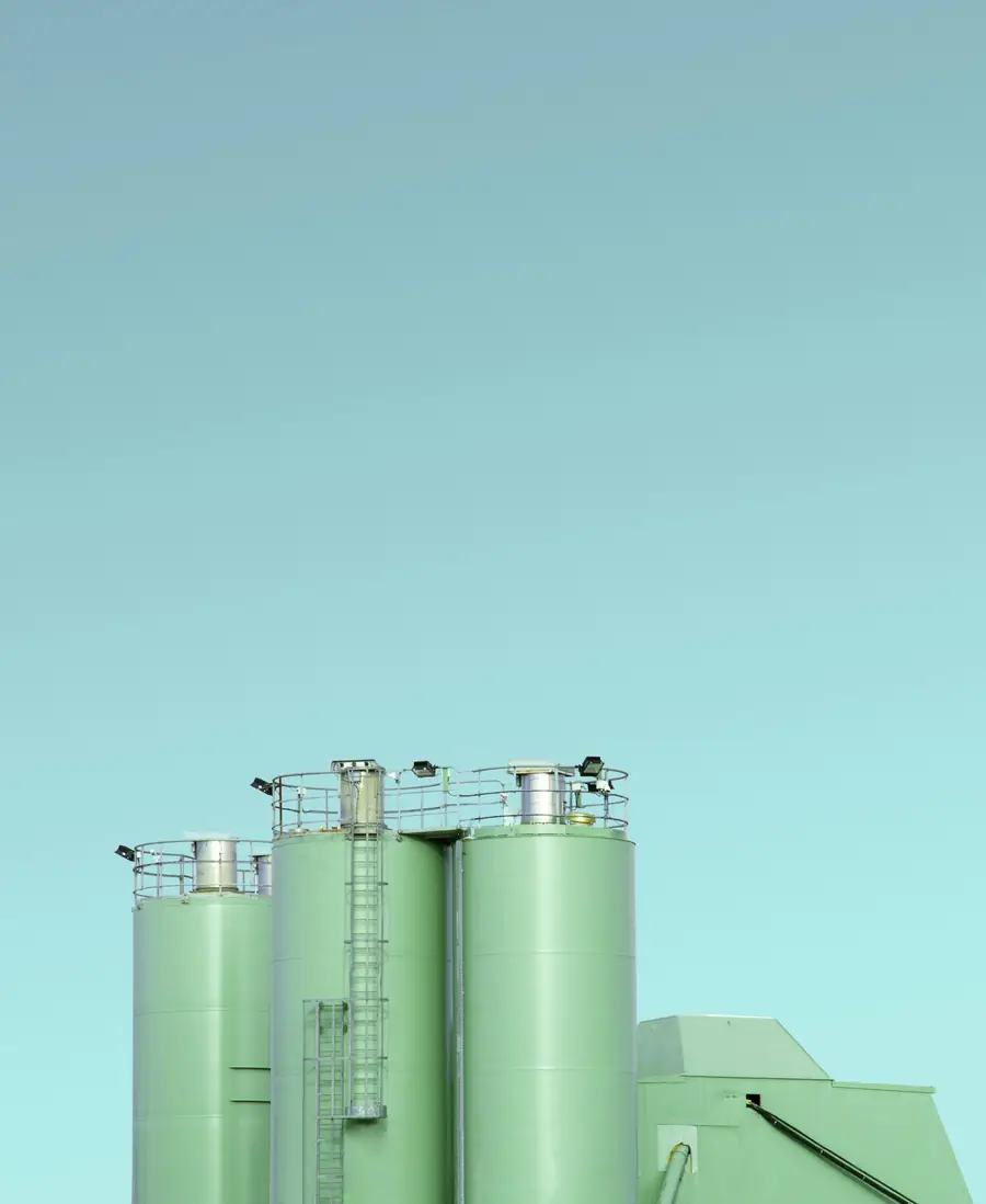 Group of green steel silos against the sky